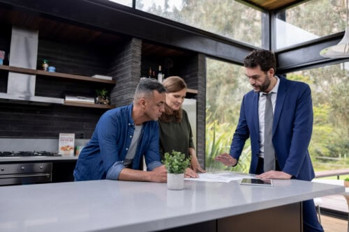 couple signs listing agreement with real estate agent