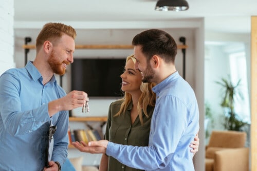 real estate agent gives keys to new homeowners