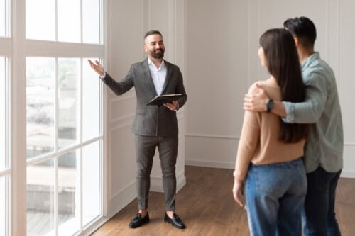 Real estate agent shows home to young couple - real estate branding